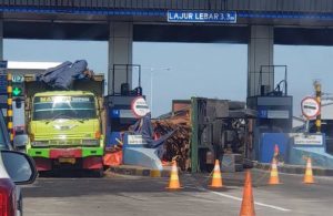 Truk muat kayu terguling di gate tol