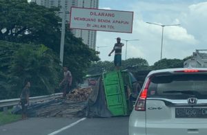 Truk Muat Kayu Terguling di Tol Satelit