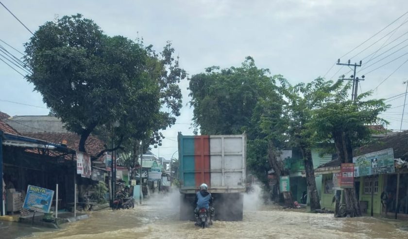 Banjir di depan Pasar Blega pagi ini (29/12). Jalur ini masih bisa dilintasi kendaraan (prm)