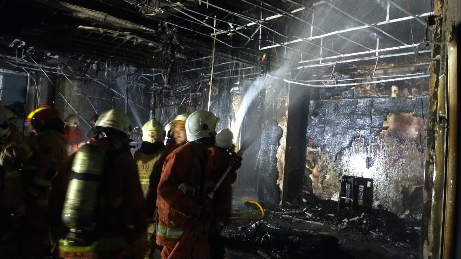 Petugas memadamkan kebakaran di Asrama Bougenvile, Gedung Balai Besar Penjaminan Mutu Pendidikan (BBPMP) Jawa Timur, Jalan Ketintang Wiyata, Surabaya, Jawa Timur, Minggu (27/8/2023). Foto: Command Center Kota Surabaya