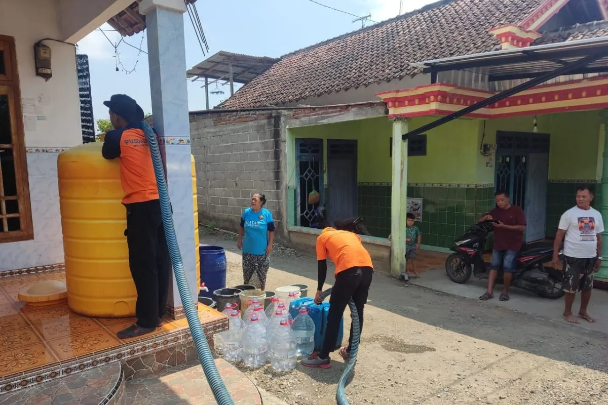 Petugas menyalurkan bantuan air bersih ke rumah-rumah warga di daerah yang cenderung kering dan tandus, di Tulungagung selatan. Foto: BPBD Tulungagung