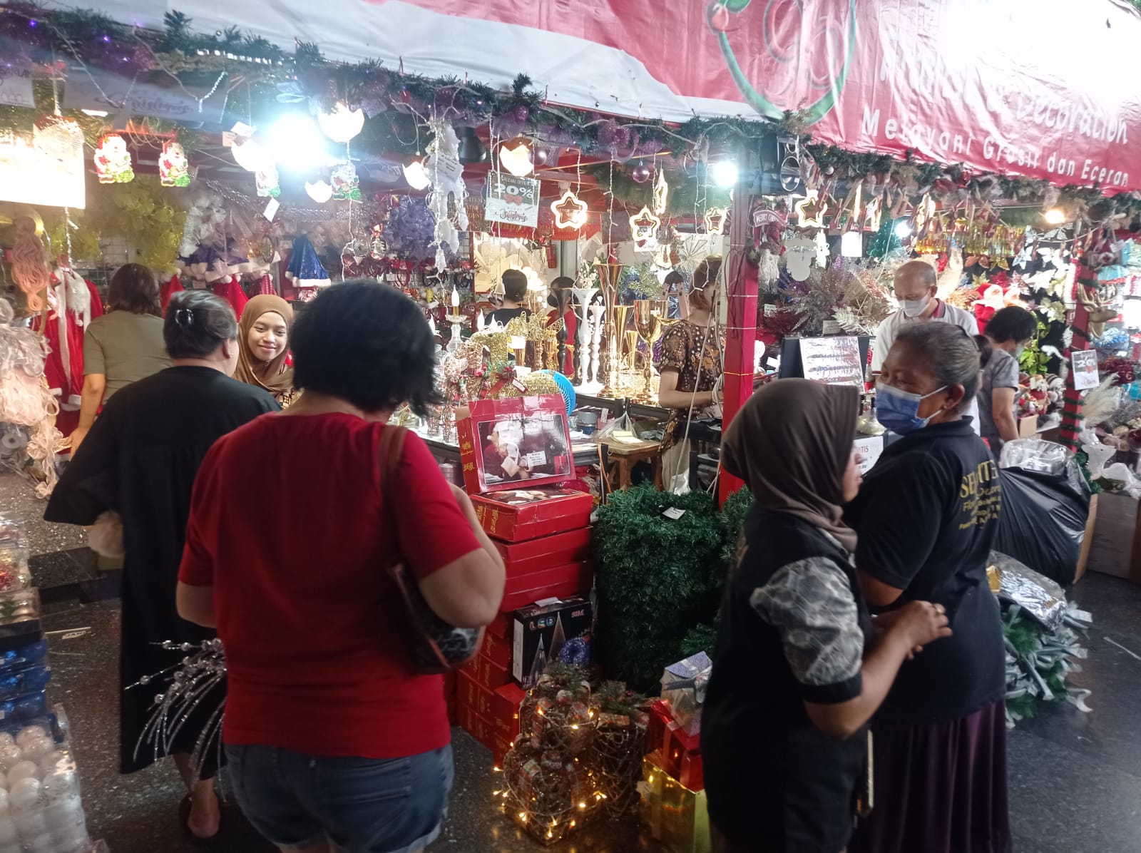 Para pembeli saat memilih pernak-pernik natal di Pasar Atom Surabaya, Jumat (15/12/2023). Foto: Risky suarasurabaya.net