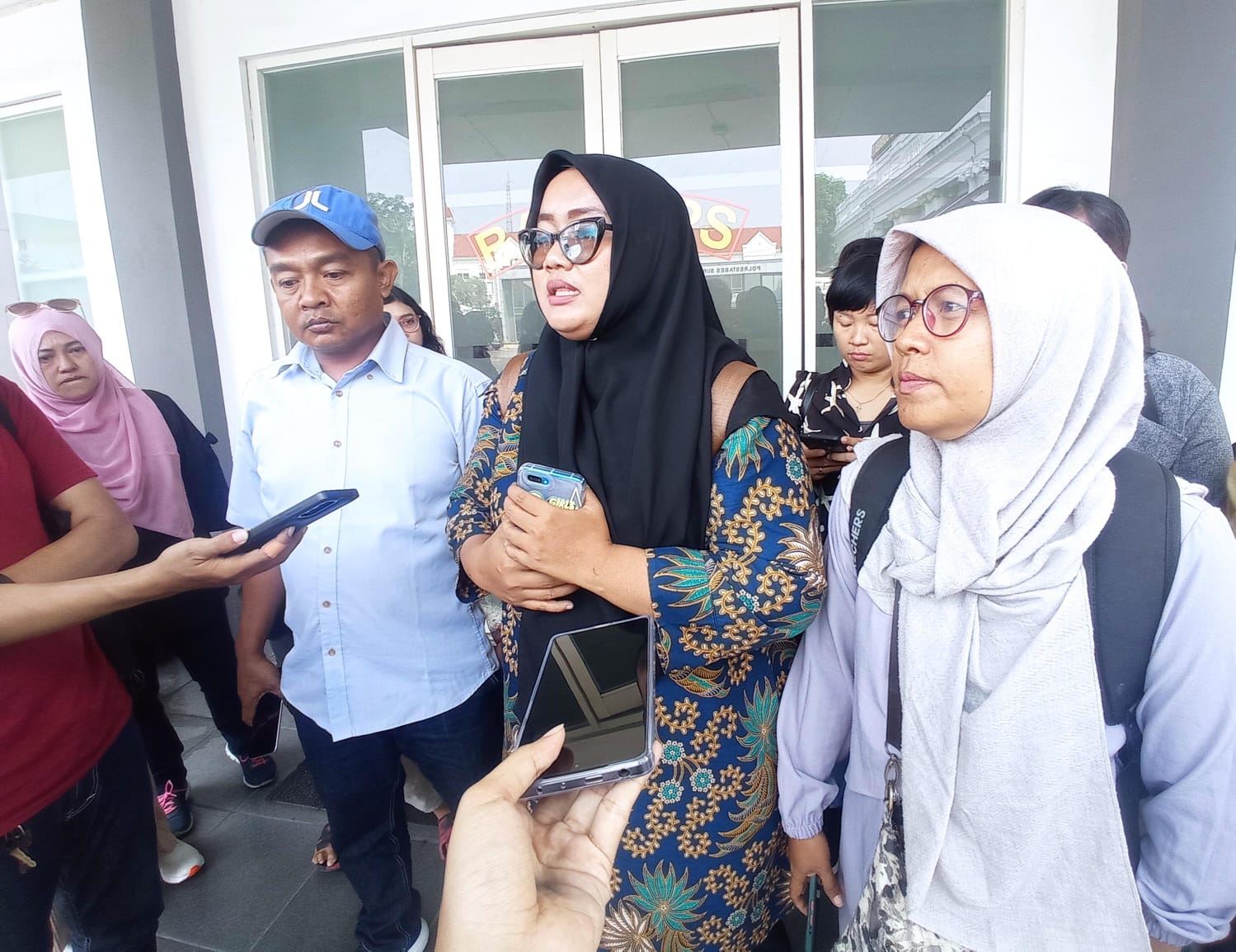 Istika (tengah) wali murid dan Dhany Yulinar (kanan) wali murid yang juga pengurus drumband SDN Klampis Ngasem 1 seusai mediasi dengan dewan juri dan KONI Surabaya di Polrestabes Surabaya, Senin (18/12/2023). Foto: Risky suarasurabaya.net