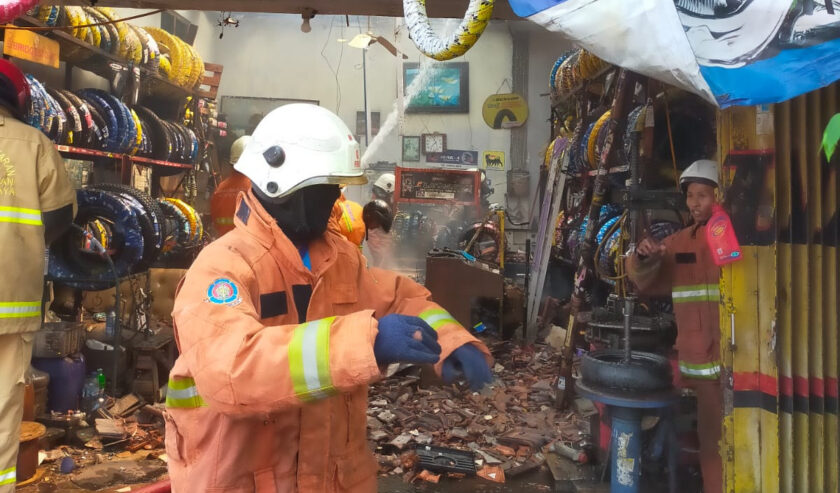 Petugas berupaya memadamkam api yang membakar sebuah rumah sekaligus toko ban di Jalan Ngaglik, Selasa (12/12/2023) siang. Foto: DPKP Surabaya