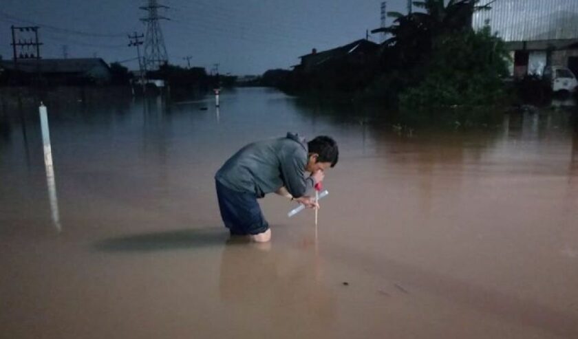 Petugas mengukur ketinggian banjir di jalur rel kereta api di wilayah Daop 4 Semarang, sehingga tidak bisa dilalui pada Kamis (14/3/2024). Foto: Humas KAI