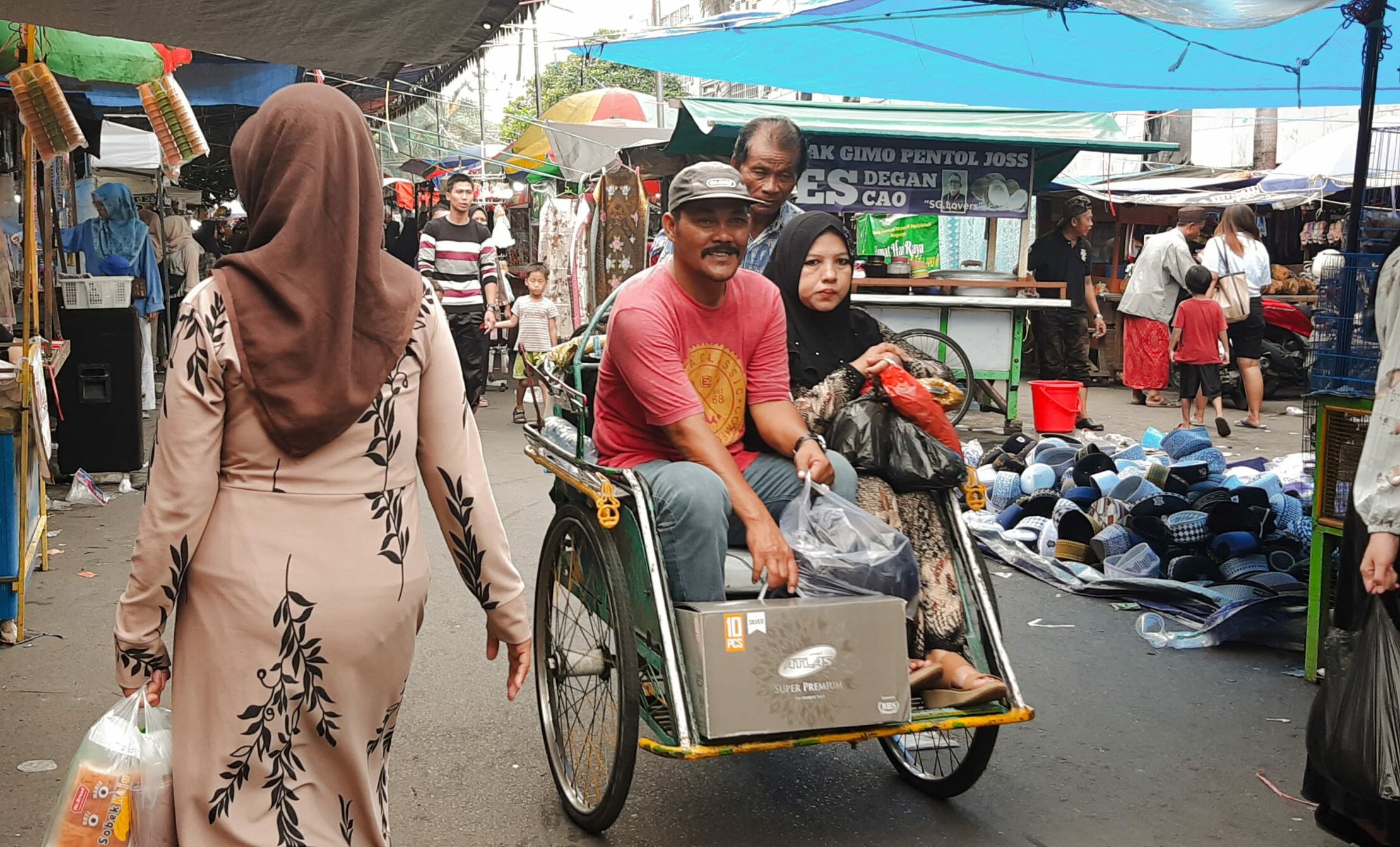 Pengunjung naik becak usai berbelanja dalam event Pasar Bandeng Kawak 2024 di Jalan Samanhudi, Gresik pada Senin (8/4/2024). Foto: Dokumen suarasurabaya.net