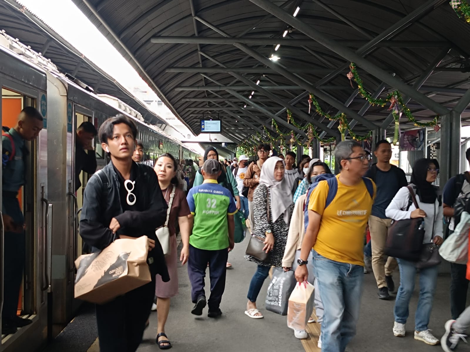 Para penumpang saat turun dari kereta api di Stasiun Surabaya Gubeng, Minggu (21/4/2024). Foto: Risky suarasurabaya.net