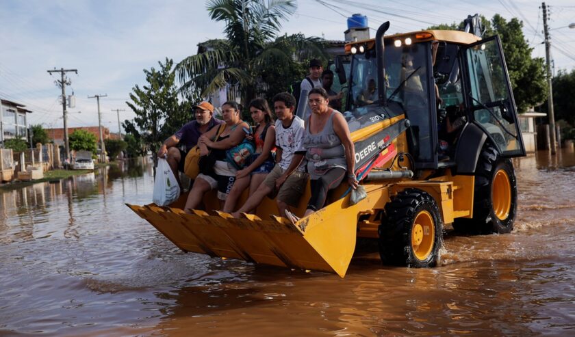 Pengungsi menaiki loader setelah rumah mereka terendam banjir di Eldorado do Sul, di Rio Grande do Sul, Brasil pada 7 Mei 2024. Foto: Reuters