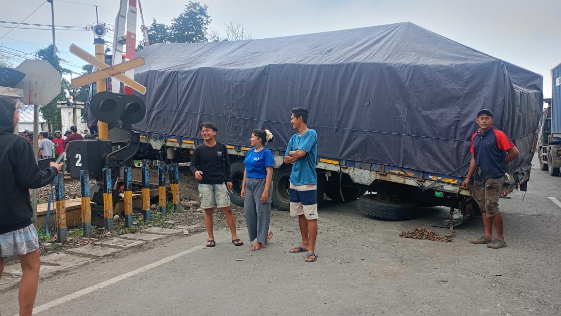 Truk tronton patah as di rel perlintasan kereta api kawasan Jalan Kolonel Sugiono, Kecamatan Waru, Kabupaten Sidoarjo, Jawa Timur, Jumat (24/1/2025) pagi, sekitar pukul 09.00 WIB. Foto: Khitam via WA SS